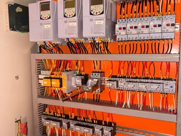Detalhe interno do painel elétrico com inversores WEG e contatores